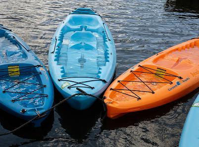 3 empty kayaks on the water